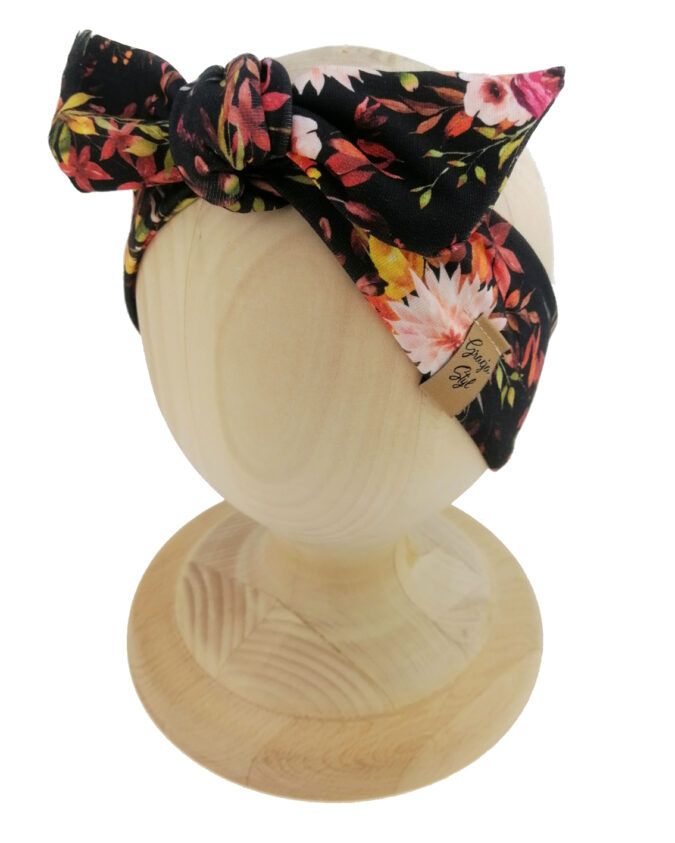 Opaska kobieca typu Pin-up marki Gracja Styl. Uszyta z bawełny petelkowej typu dresówka. Wzór opaski kwiaty na czarnym tle.
