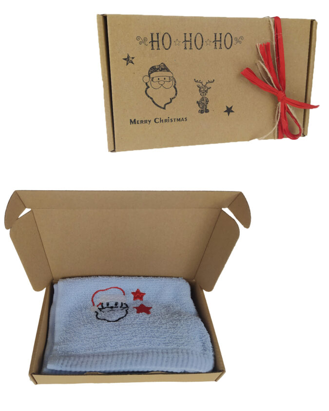 prezent w postacie ręcznika z haftem mikołaja zapakowany w pieknie przyozdobione pudełko